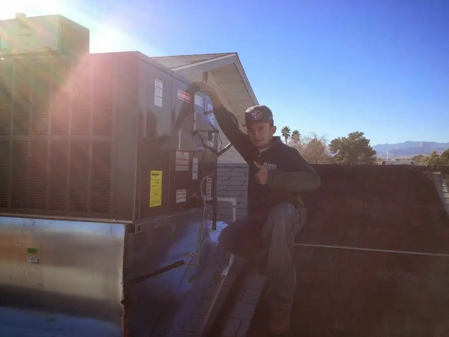 HVAC technician performing AC Tune-Up on a rooftop unit in Glennville